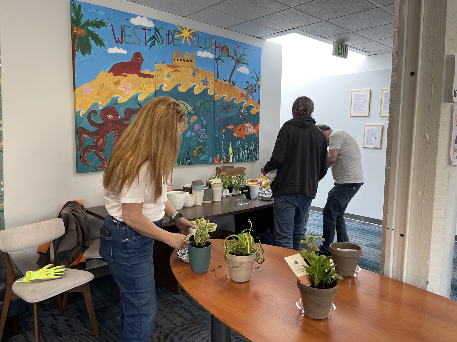 Volunteers and Clubhouse members potting plants together