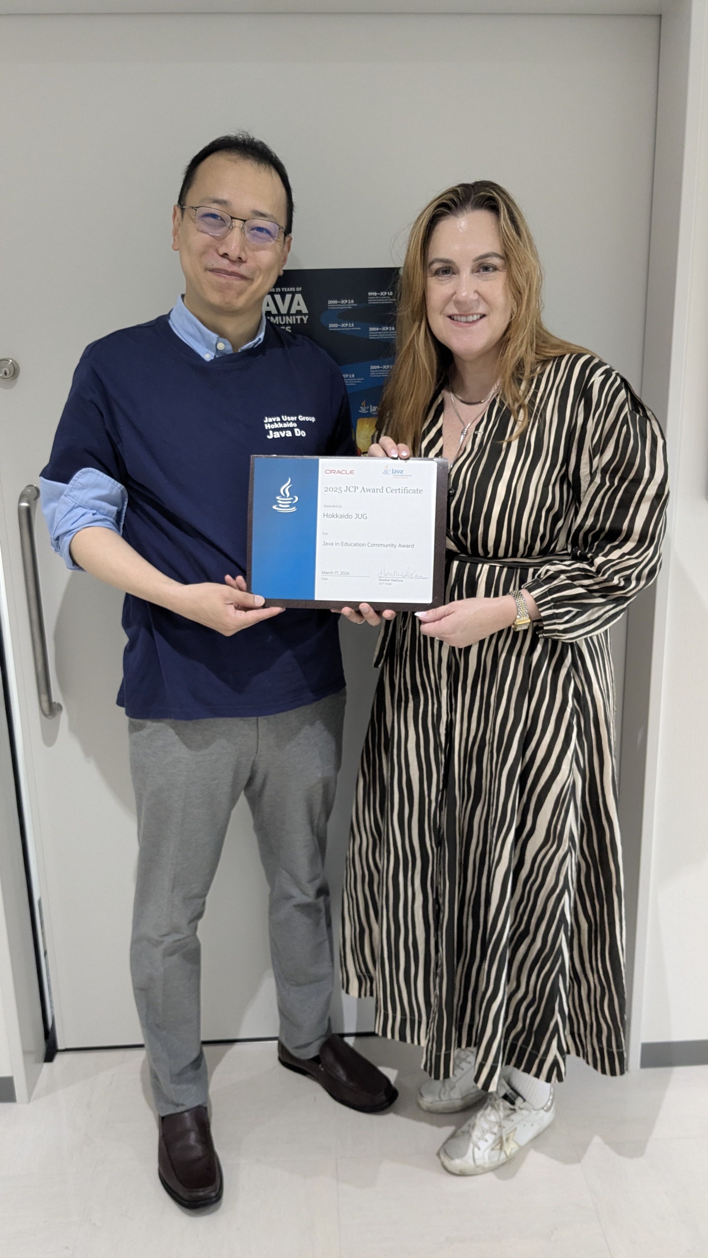 Heather VanCura and a Hokkaido Java User Group member holding an award